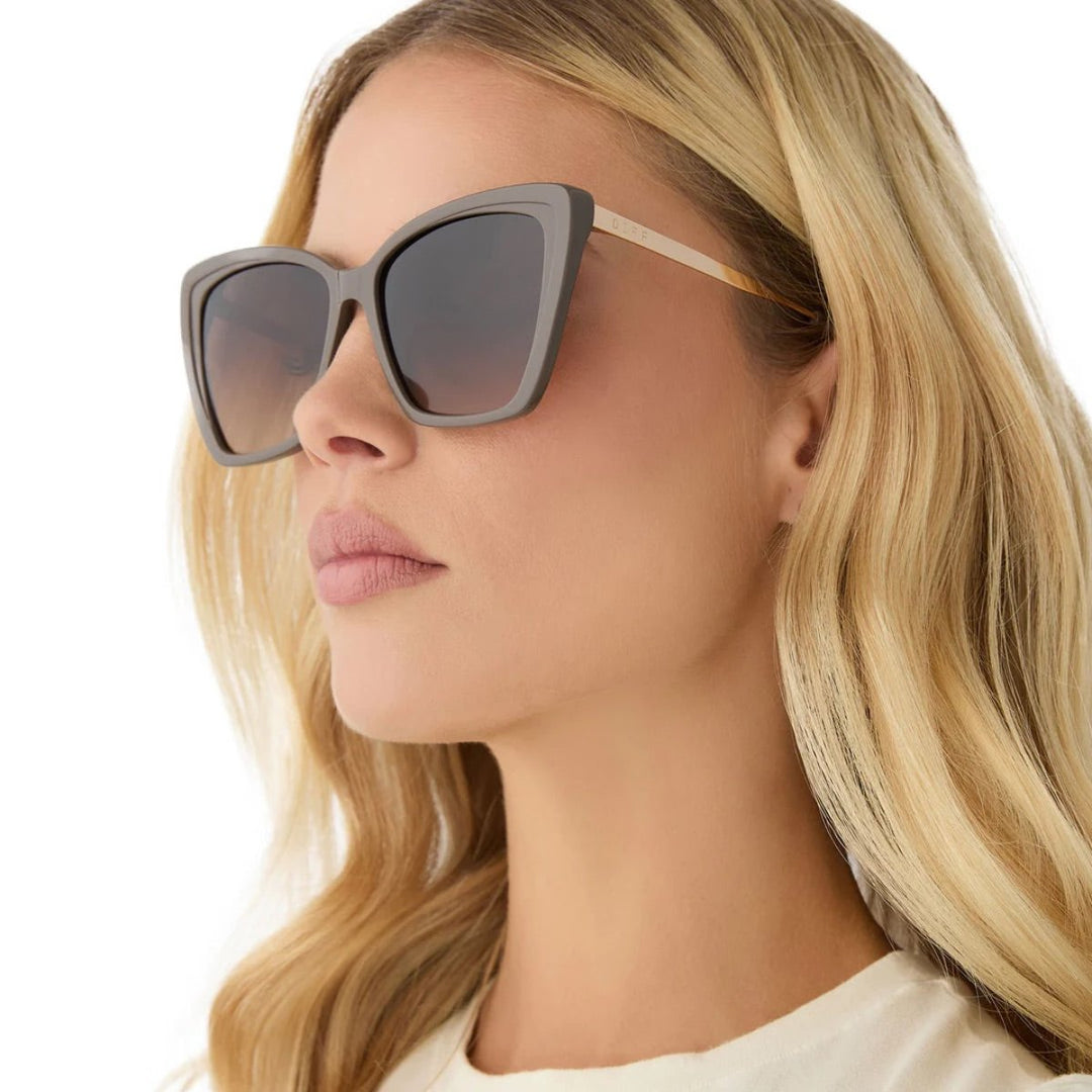 Cat-eye sunglasses with tinted lenses on a white background.