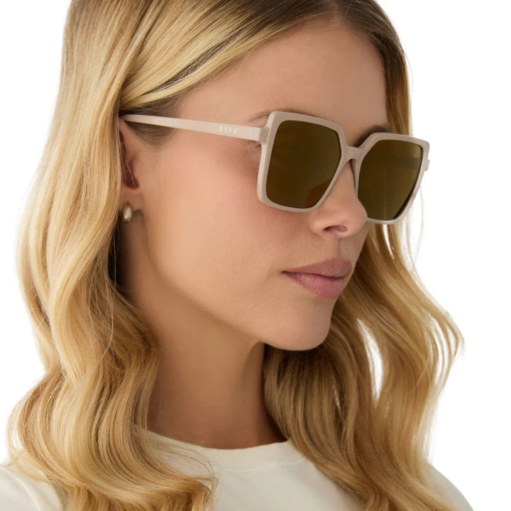 Beige-framed sunglasses with brown tinted lenses on a white background.