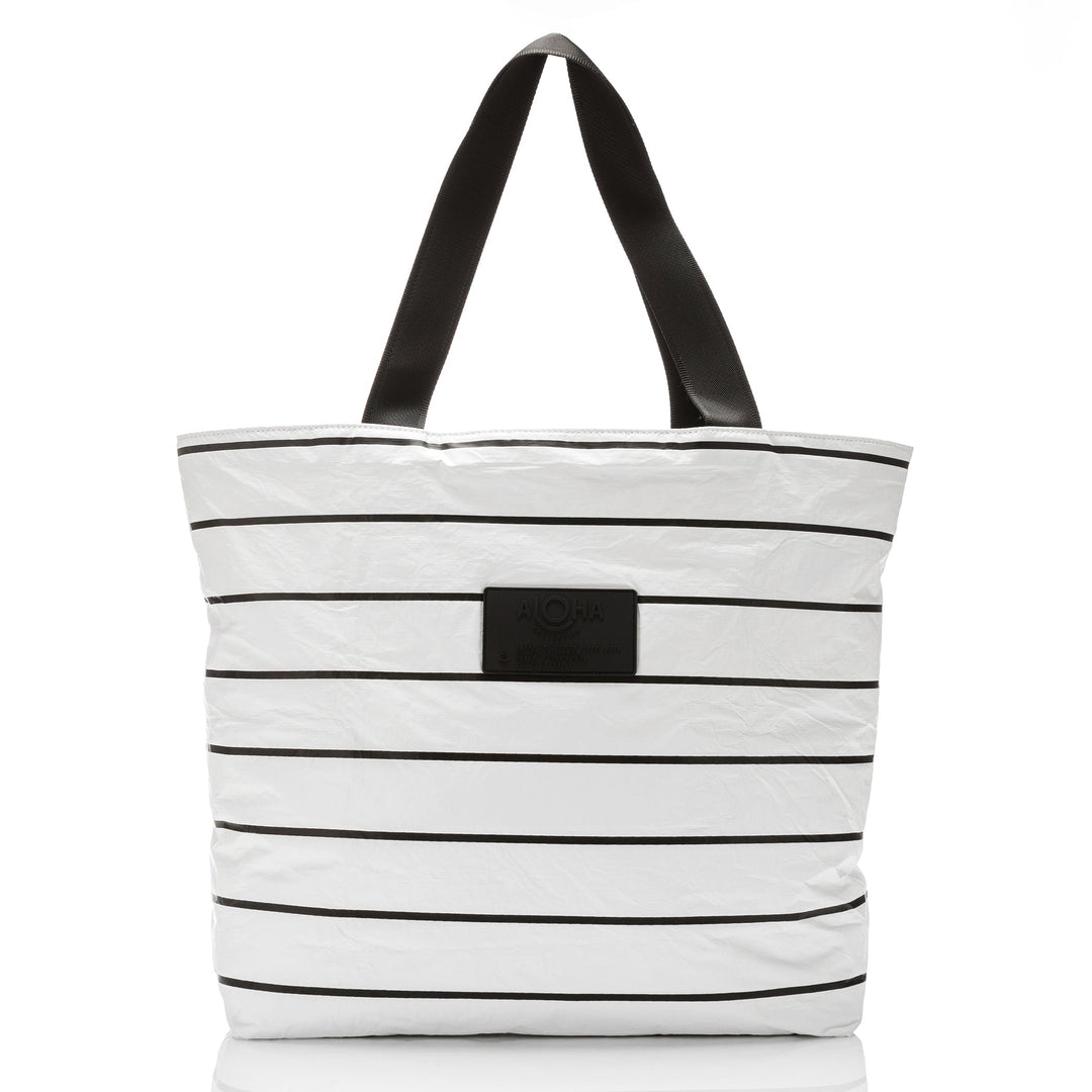 White Pinstripe Day Tripper tote with horizontal black stripes and black straps, front view with the ALOHA patch