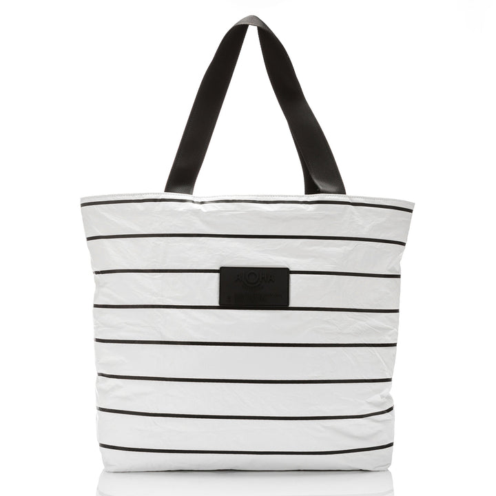 White Pinstripe Day Tripper tote with horizontal black stripes and black straps, front view with the ALOHA patch