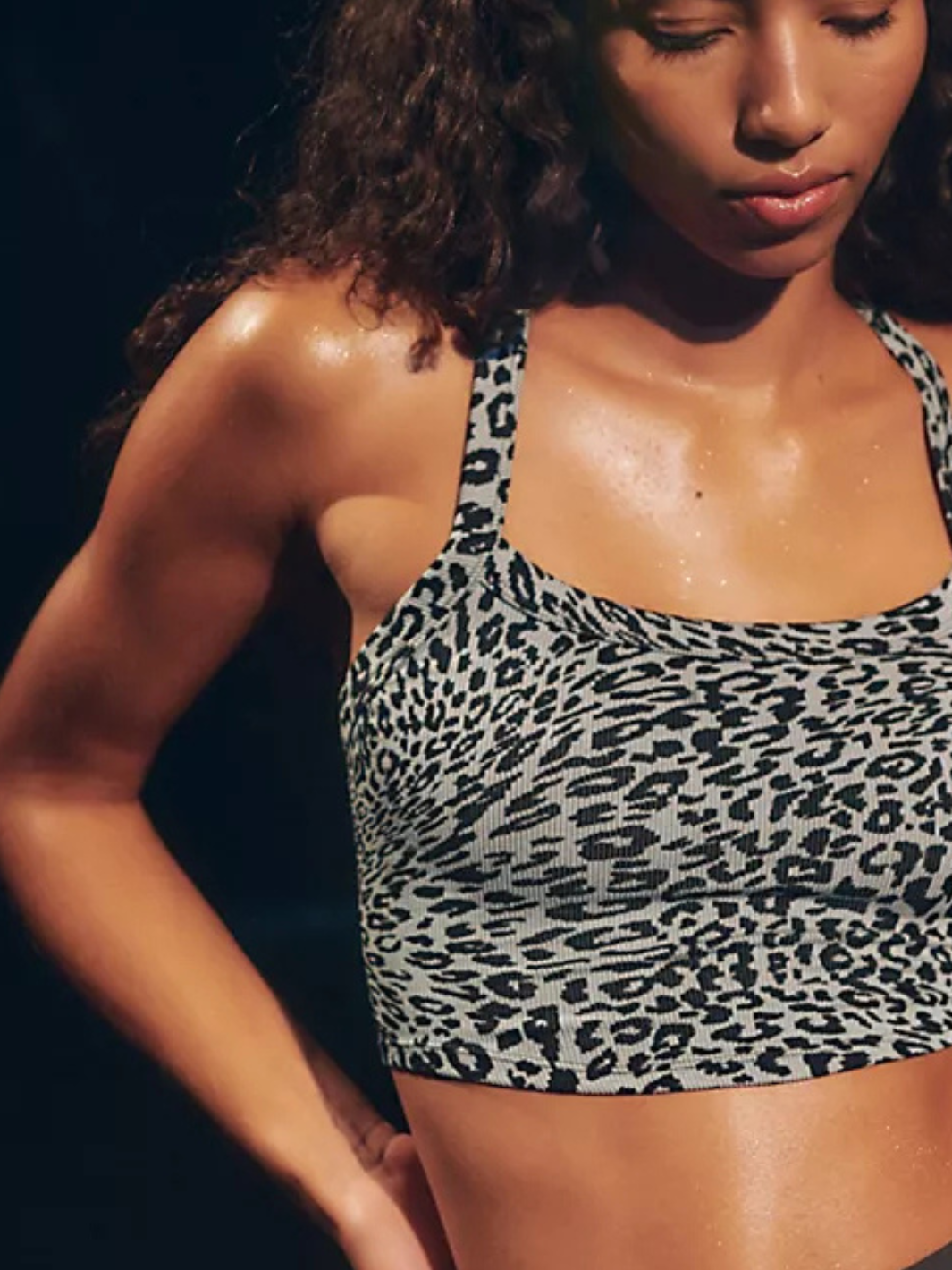 Stylish model wearing the FREE PEOPLE - All Clear Cami Leopard Top, featuring a chic square neckline and criss-cross back.