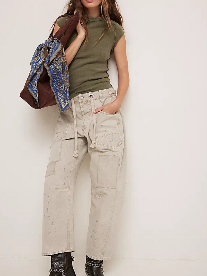 Model showcases the FREE PEOPLE - Ever Had Tee, a stylish ribbed knit essential, paired with trendy pants and accessories.