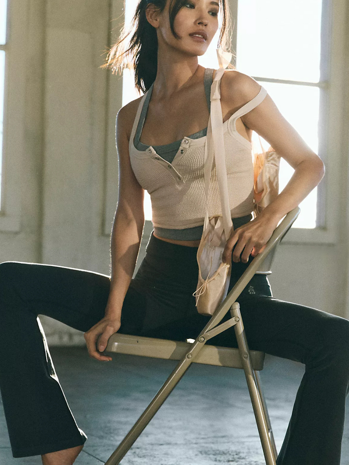 Model showcases FREE PEOPLE - Go To Smooth Flare pants, blending style and comfort for versatile activewear.