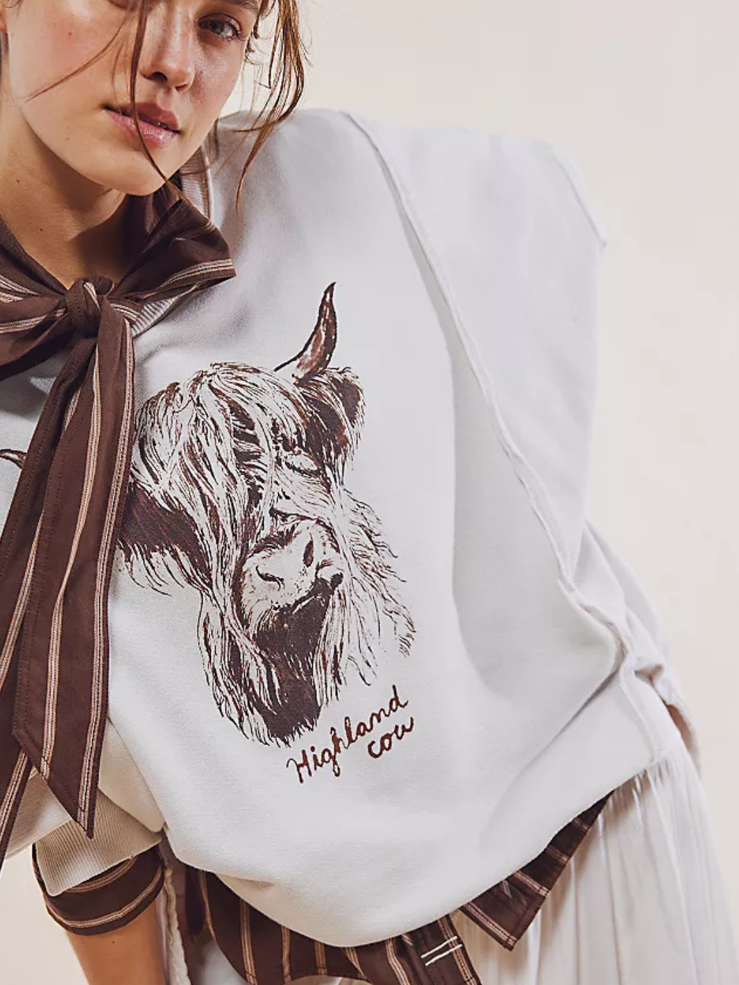 Relaxed model showcasing the FREE PEOPLE - Graphic Camden Highland Cow long sleeve with vintage vibes and a slouchy fit.