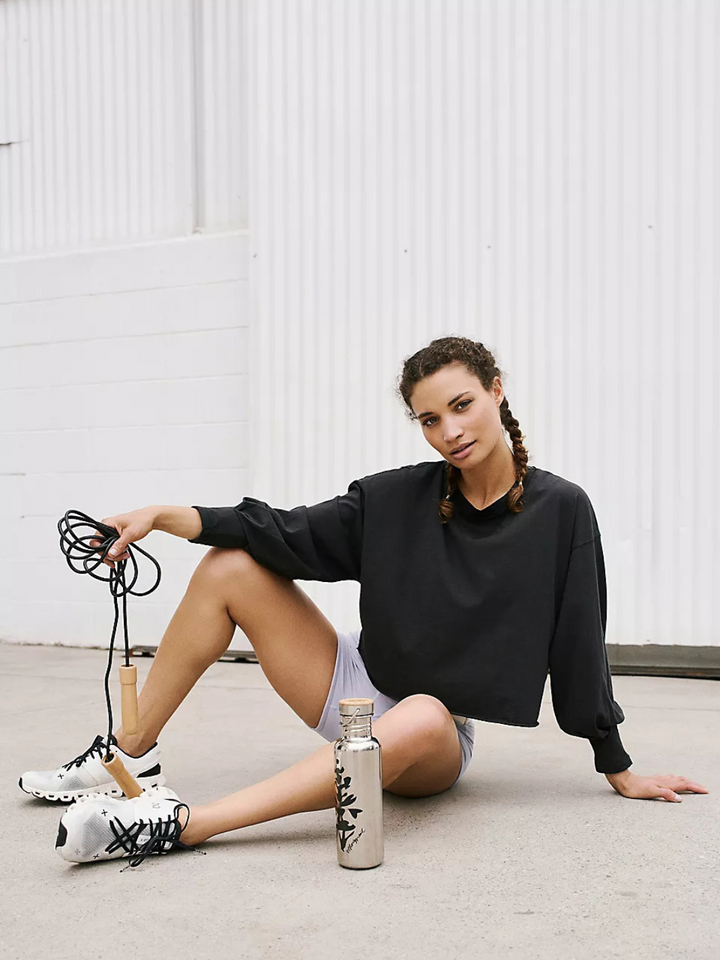 Model showcases the FREE PEOPLE - Inspire Layer long sleeve tee, perfect for effortless layering and casual style.