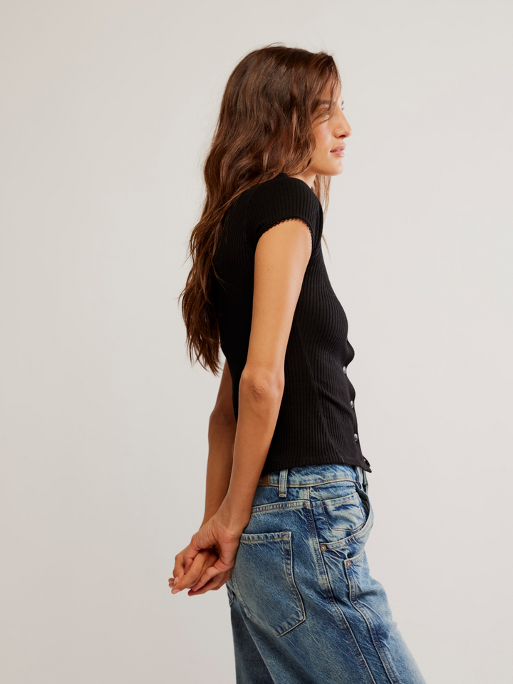 Stylish model showcasing the FREE PEOPLE - Most Wanted Cardi, a cute shrunken cardigan with ribbed fabric.