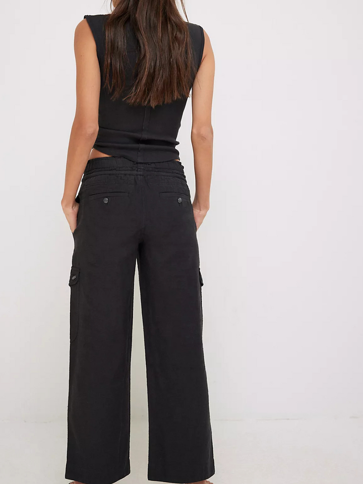 Stylish woman wearing FREE PEOPLE - Park Ave Pant, showcasing utility details and a modern, flared silhouette.