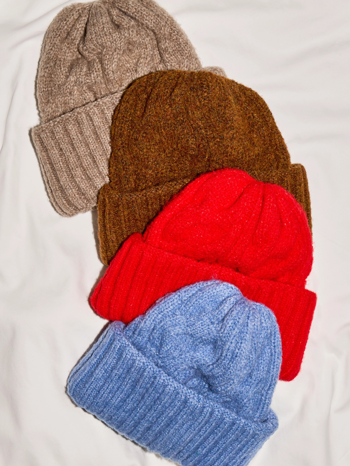 FREE PEOPLE The Coast Line Beanie: cozy knit, chunky rib cuff, in beige, brown, red, and blue.
