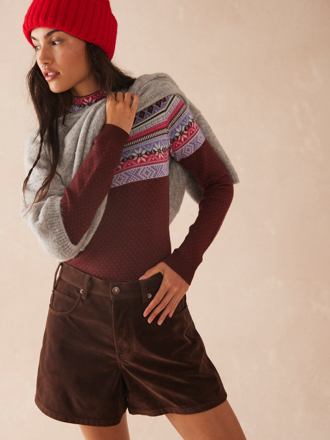 Stylish woman wearing FREE PEOPLE - We The Free Tippi Vegan Suede Short with a cozy sweater and red beanie.