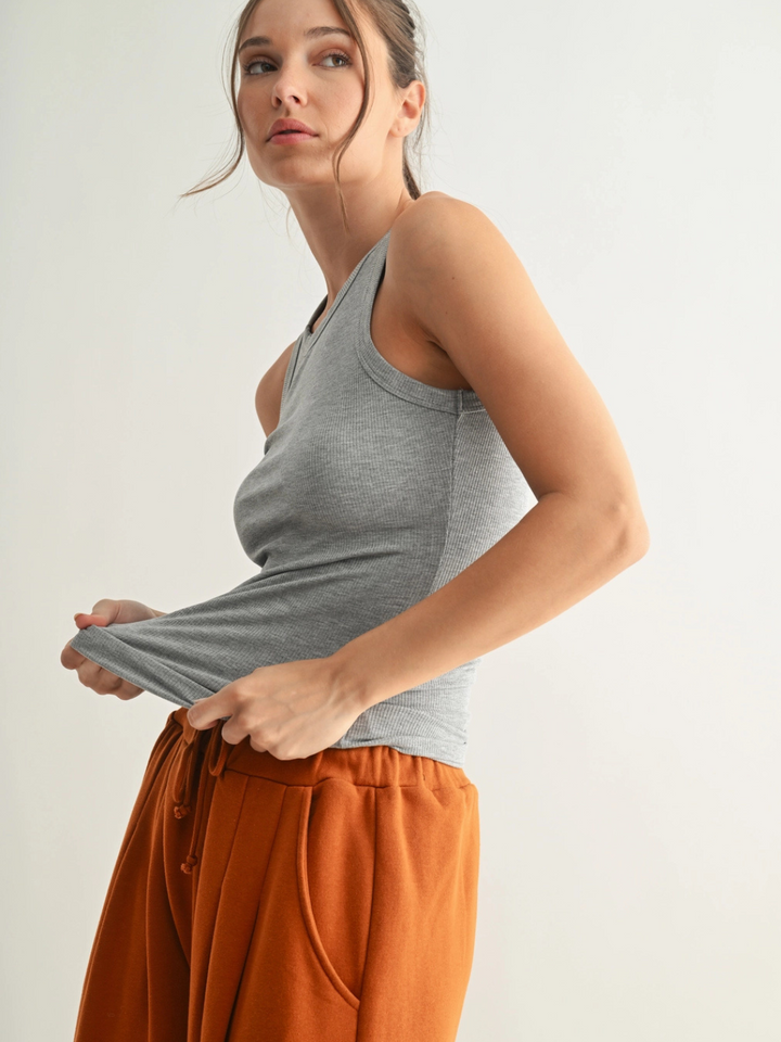 Go-To Micro Rib Tank Top on a model; heather gray, sleek body-hugging fit with rust-orange joggers.