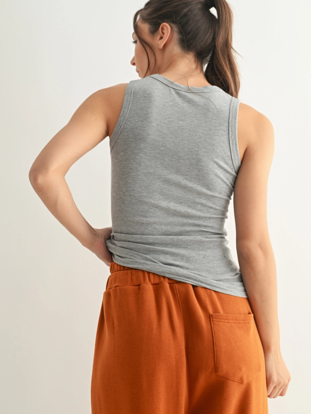 Go-To Micro Rib Tank Top in grey, back view on model with rust-orange pants.