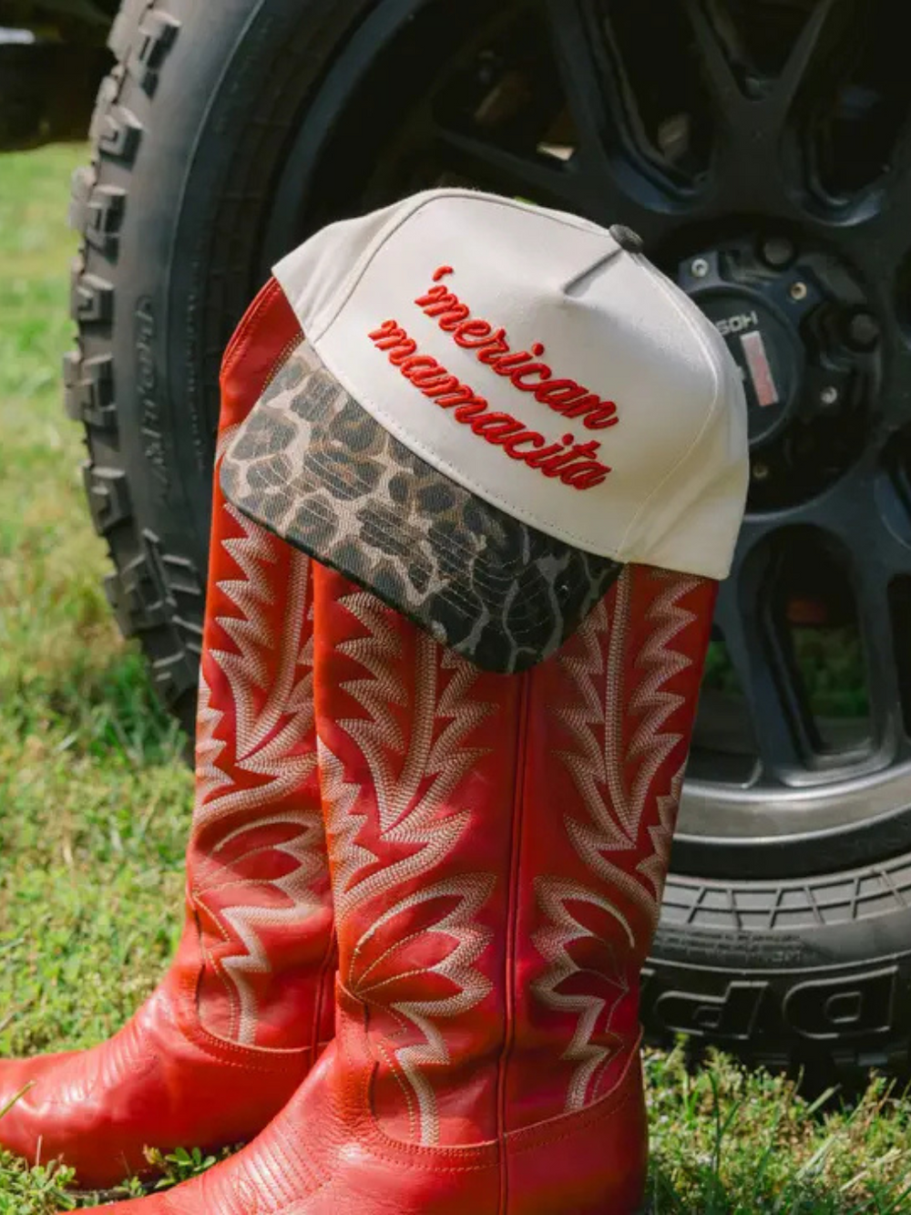 Bold KENZKUSTOMZ - 'Merican Mamacita trucker hat paired with striking red boots, showcasing a fierce Americana style.