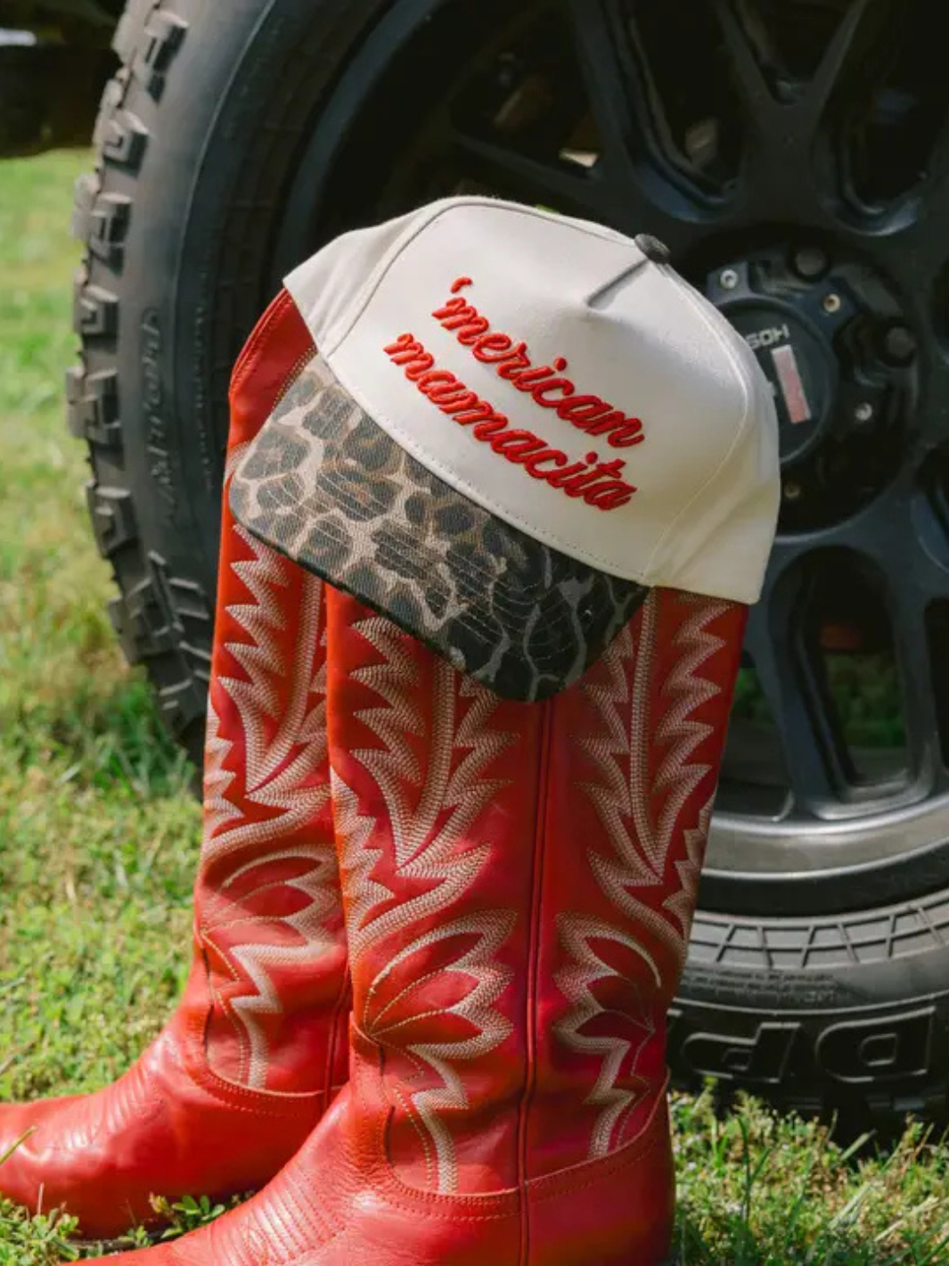 Bold KENZKUSTOMZ - 'Merican Mamacita trucker hat paired with striking red boots, showcasing a fierce Americana style.