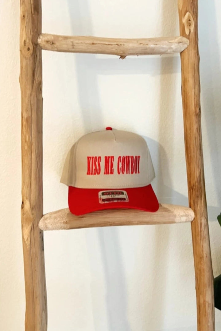Kiss Me Cowboy Baseball Hat in red and beige, showcasing bold embroidery and stylish design for cowgirls.