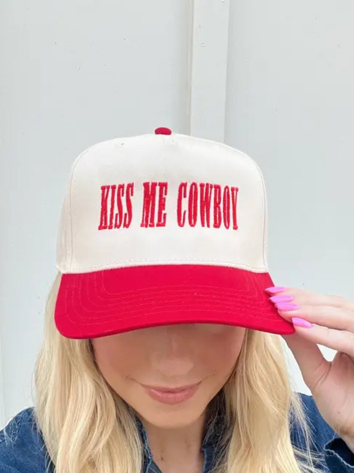 Stylish red-and-natural Kiss Me Cowboy Baseball Hat adds sass to any outfit with flirty embroidery and structured design.