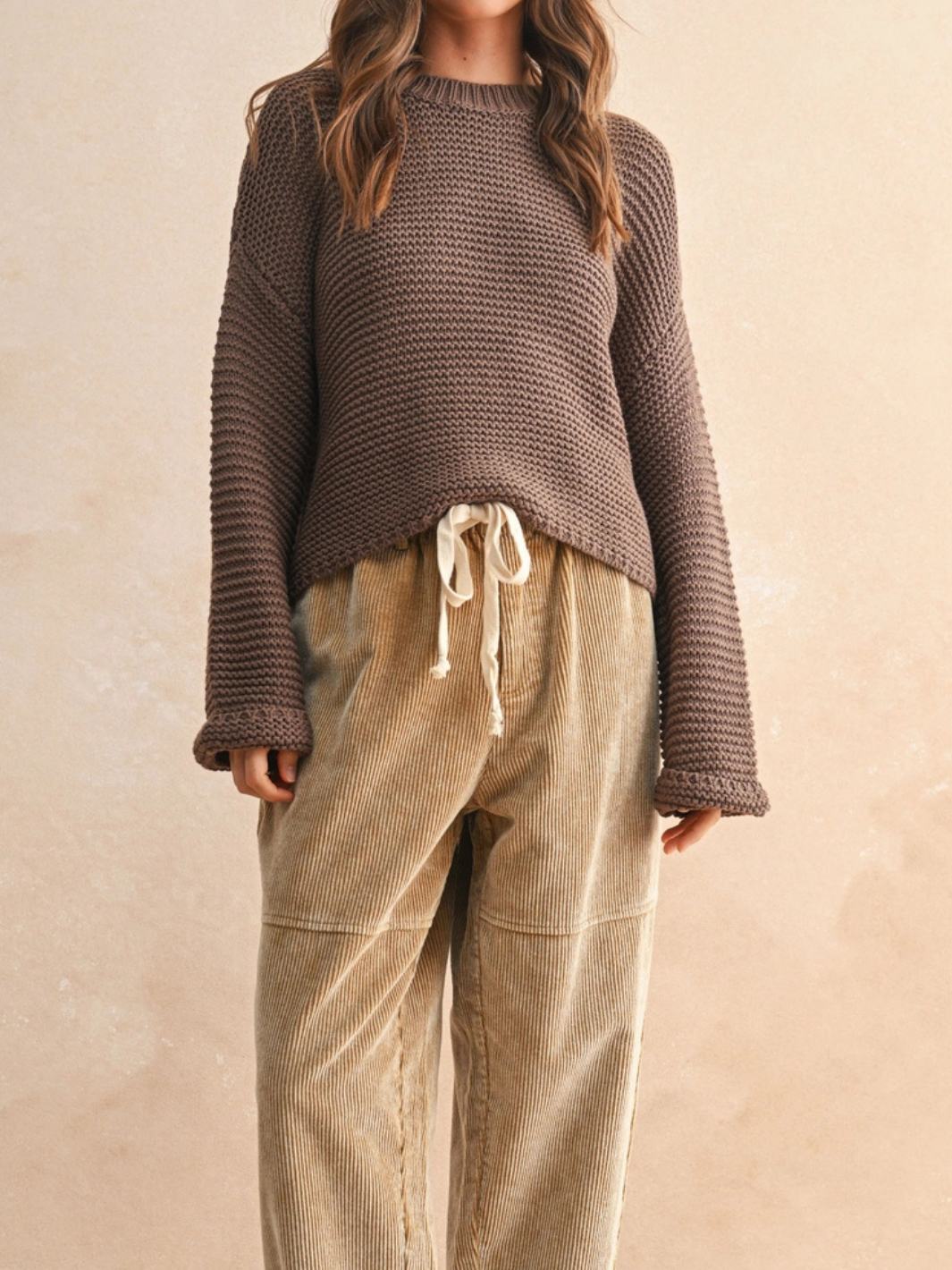 Laid-Back Luxe Chunky Knit Top in brown, relaxed oversized fit with round neckline; paired with beige corduroy pants.