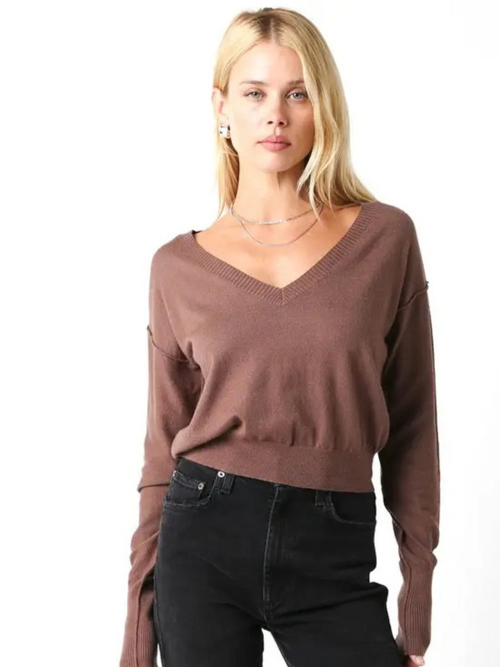 Model wearing Loren Lightweight V-Neck Knit Sweater in taupe with black jeans.