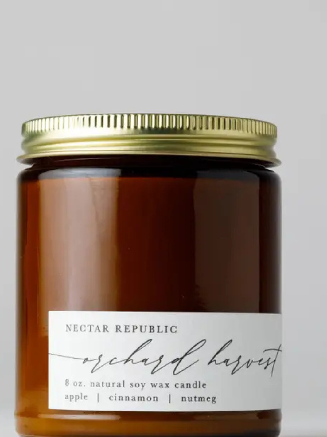 Nectar Republic Orchard Harvest 8 oz amber soy candle in glass jar with gold lid, apple, cinnamon, nutmeg scent.