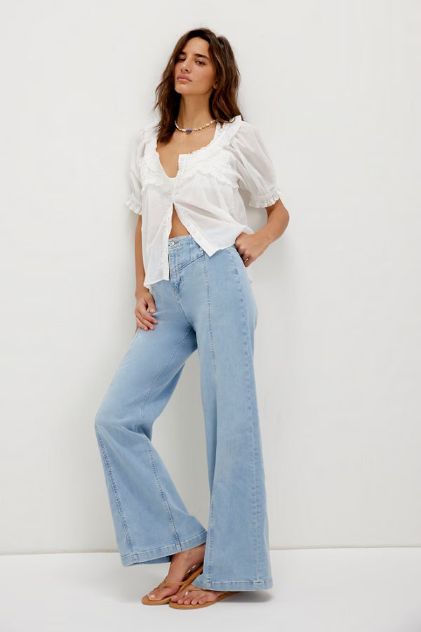 Model wearing FREE PEOPLE Libre Wide-Leg Jeans in light wash, high-rise with seamed paneling.