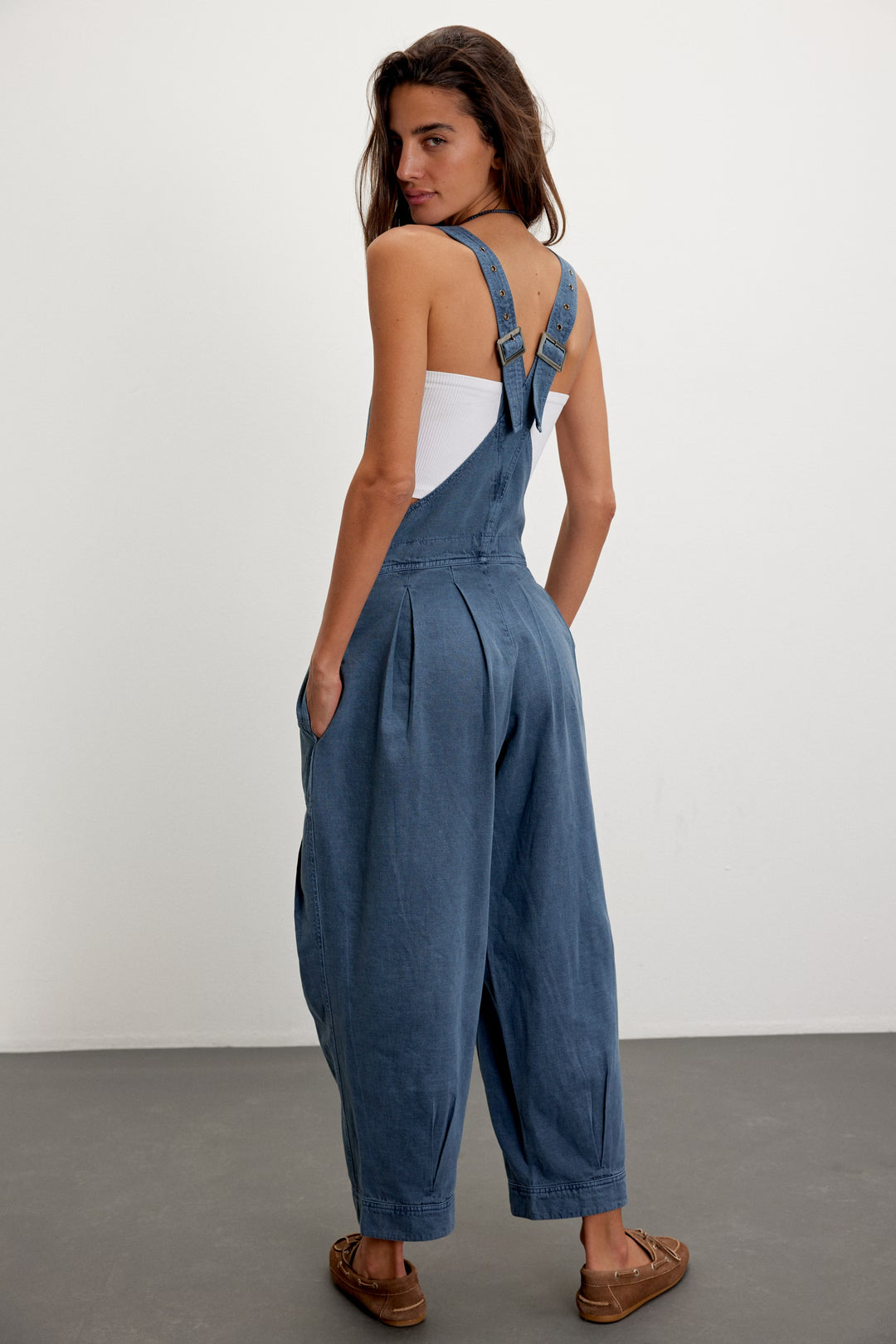 Back view of blue denim Felix Tapered Overall with adjustable straps and tapered legs.