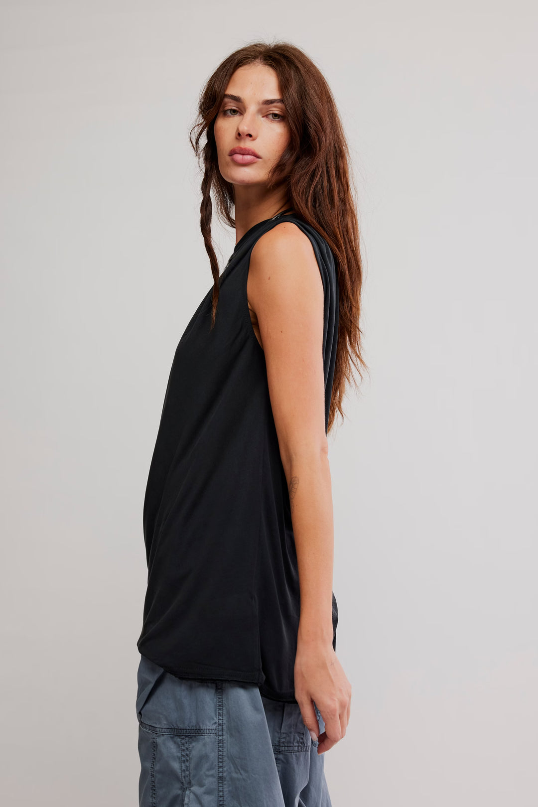 Model wearing Free People Cascadia Tunic, black draped top with off-the-shoulder neckline and relaxed fit.