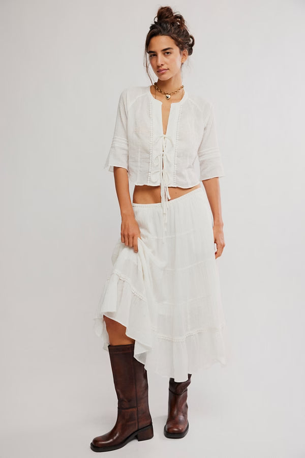 FREE PEOPLE - The Bright Side Top, white tie-front blouse with embroidery, paired with a white skirt and brown boots.