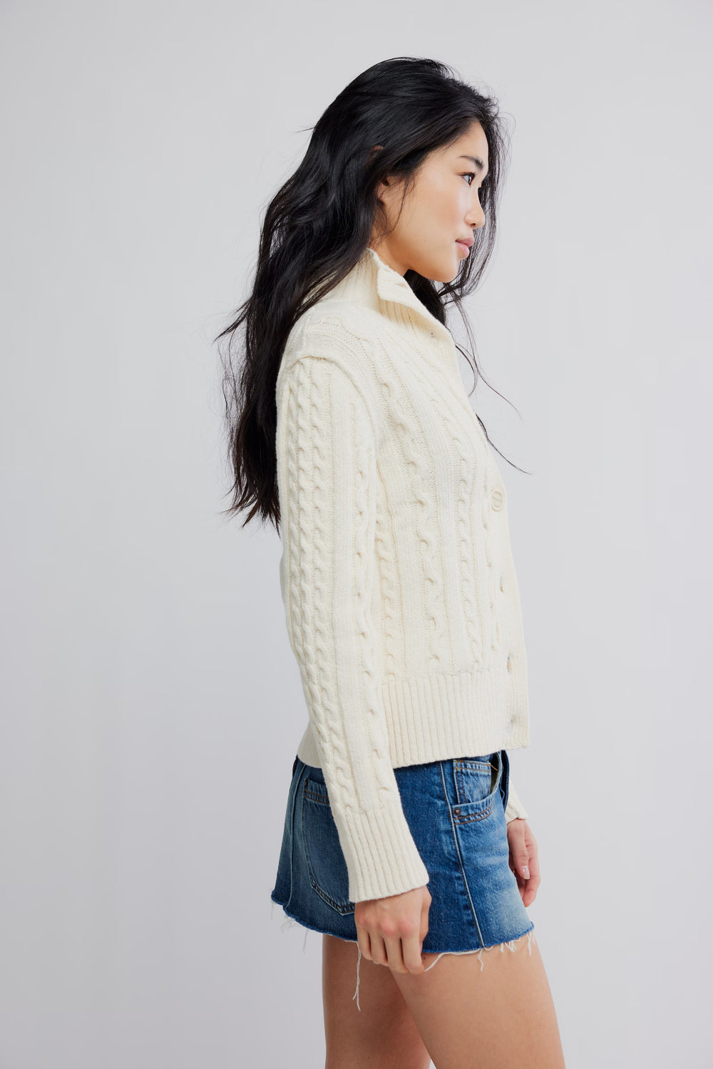Free People WTF Cable Collar Cardi on model: cream cable-knit cardigan with chunky cables and high collar.