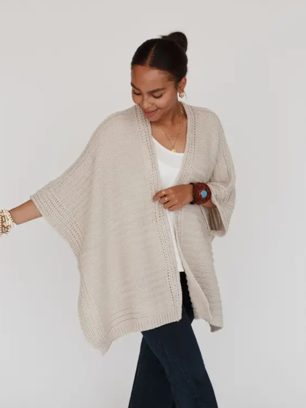 Beige So Deserving Knit Rauna open-front poncho cardigan with border-knit trim on model
