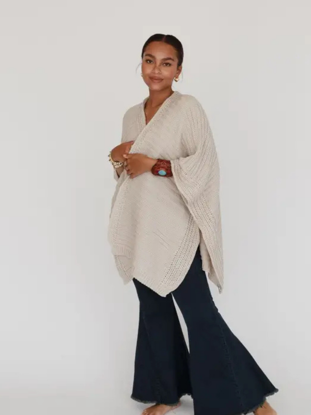 So Deserving Knit Rauna cream open-front poncho cardigan on model with dark wide-leg jeans.