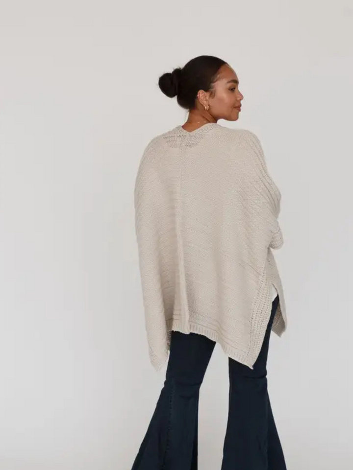 So Deserving Knit Rauna beige open-front poncho cardigan with border stitch trim worn by model.