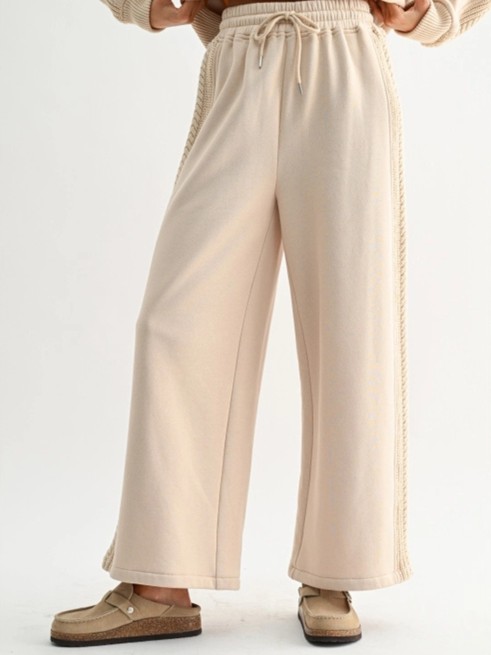 Beige Aria Cable Knit Wide Leg Pant with drawstring waist and cable-knit side panels.