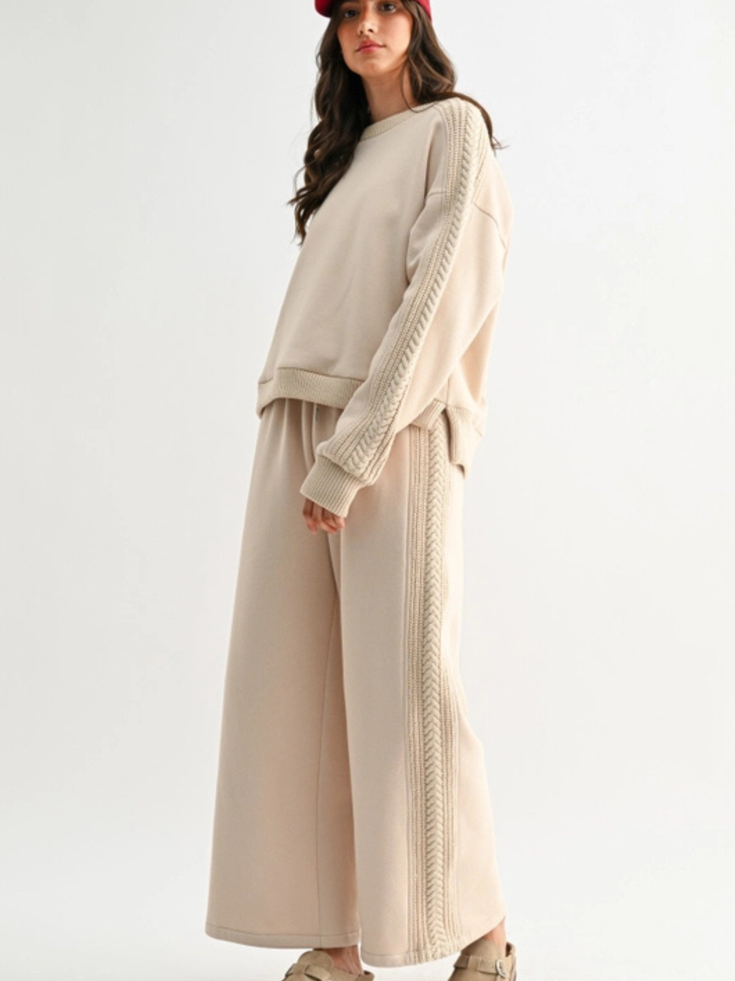 Model wearing The Aria Cable Knit Wide Leg Pant loungewear set in beige plush knit with cable-knit side stripe.