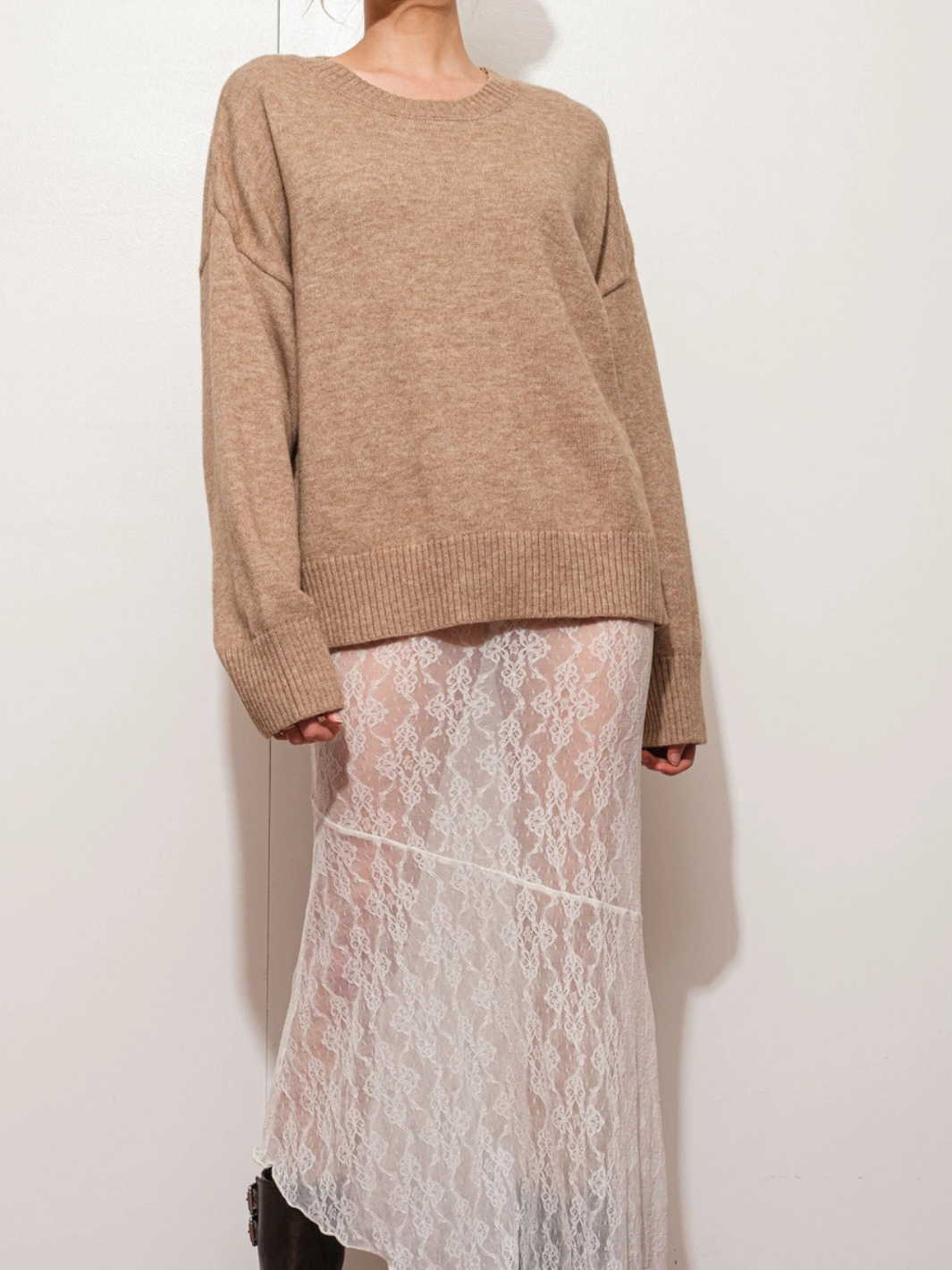 The Boston Oversized Knit Sweater in taupe with a relaxed silhouette, paired with a white lace skirt.