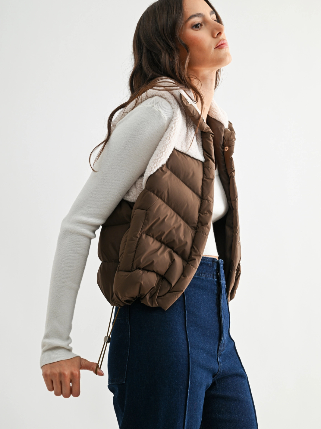 The Willow Sherpa Puffer Vest: brown quilted puffer with plush sherpa collar and lining over a light gray top.