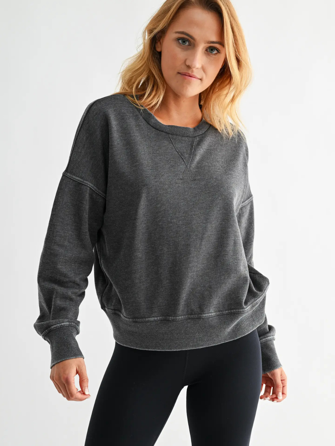 Model in Vintage Fade Fleece Pullover: dark gray, relaxed-fit crewneck with cross V-stitch and ribbed cuffs.