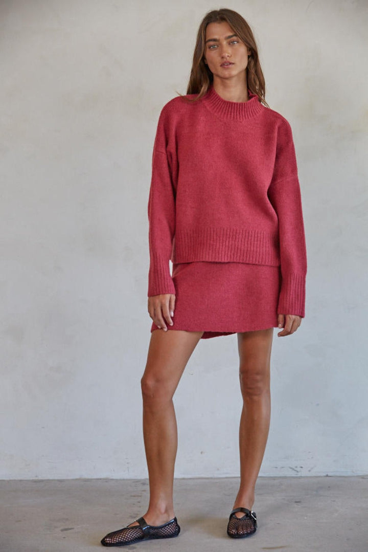 Person standing in sweater and skirt combo