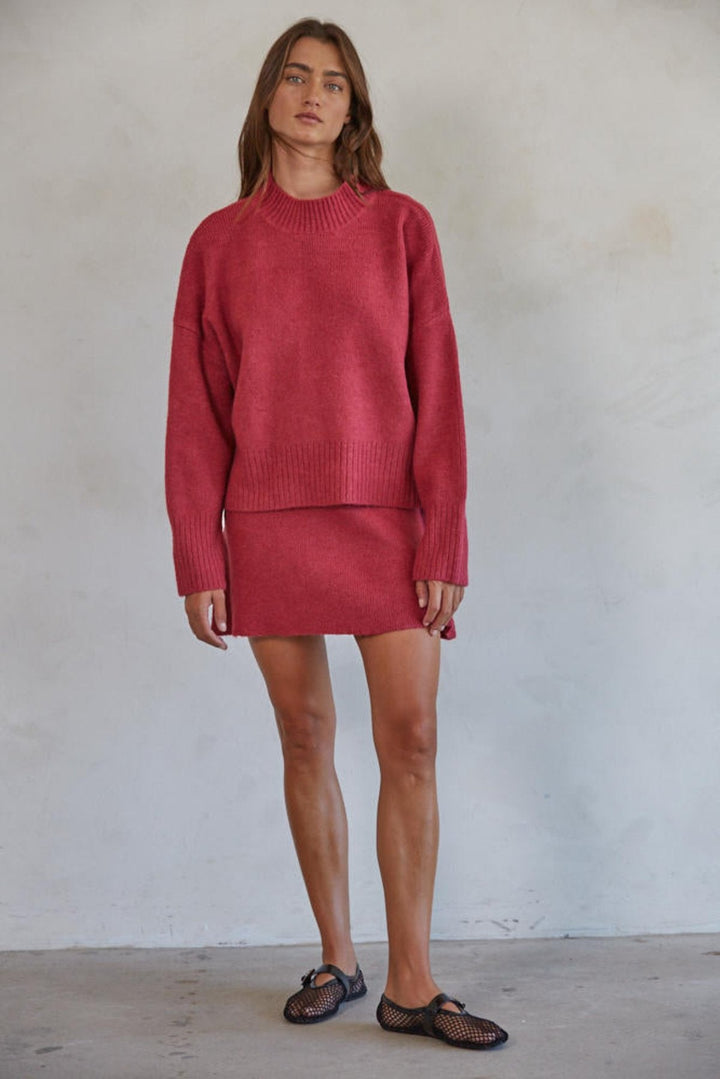 Person standing in sweater and skirt combo