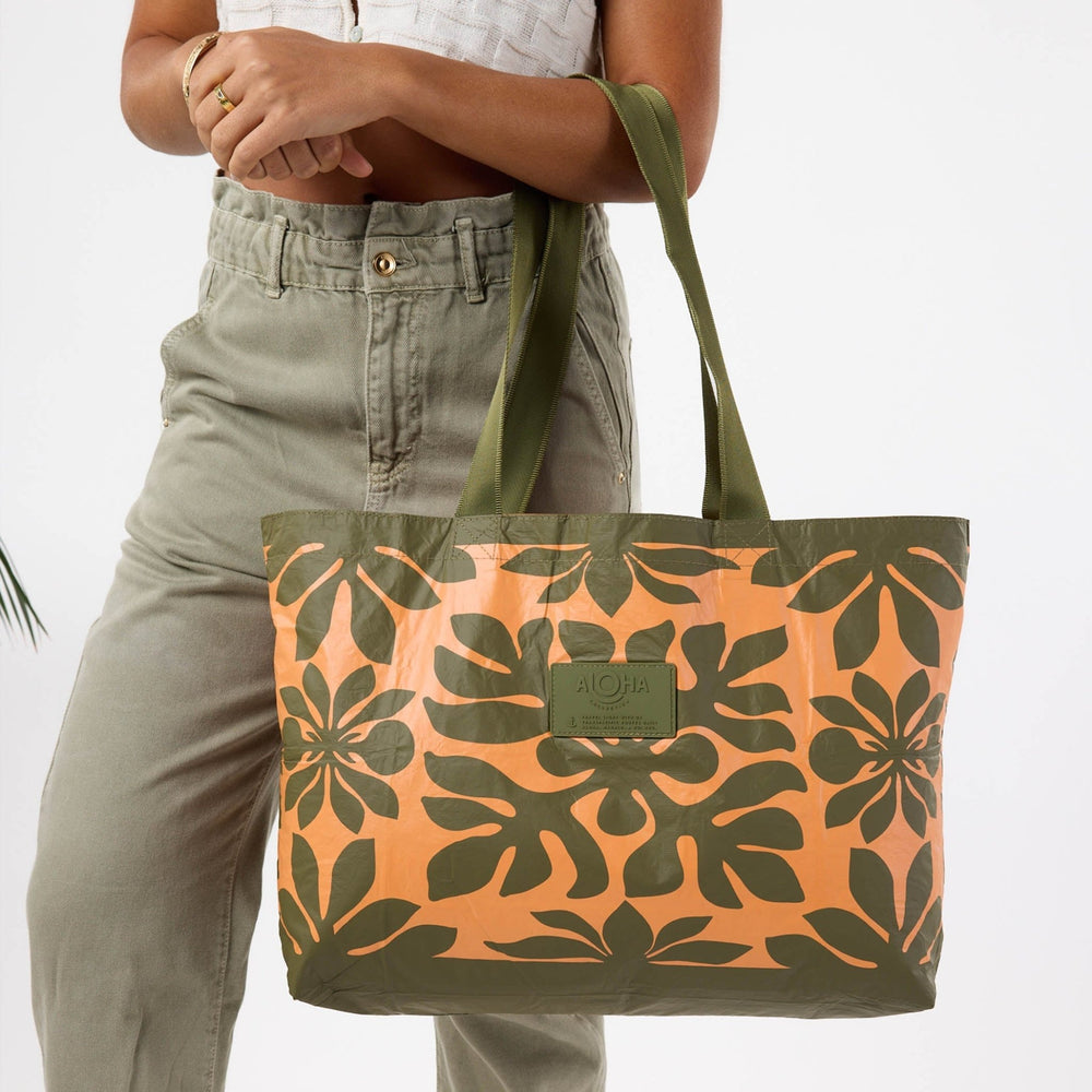 Woman in olive trousers carrying the Kaulu Holo Holo tote on her shoulder