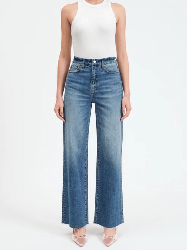 Daze Denim Far Out High Rise Wide Leg Jeans in blue on a model wearing a white top.