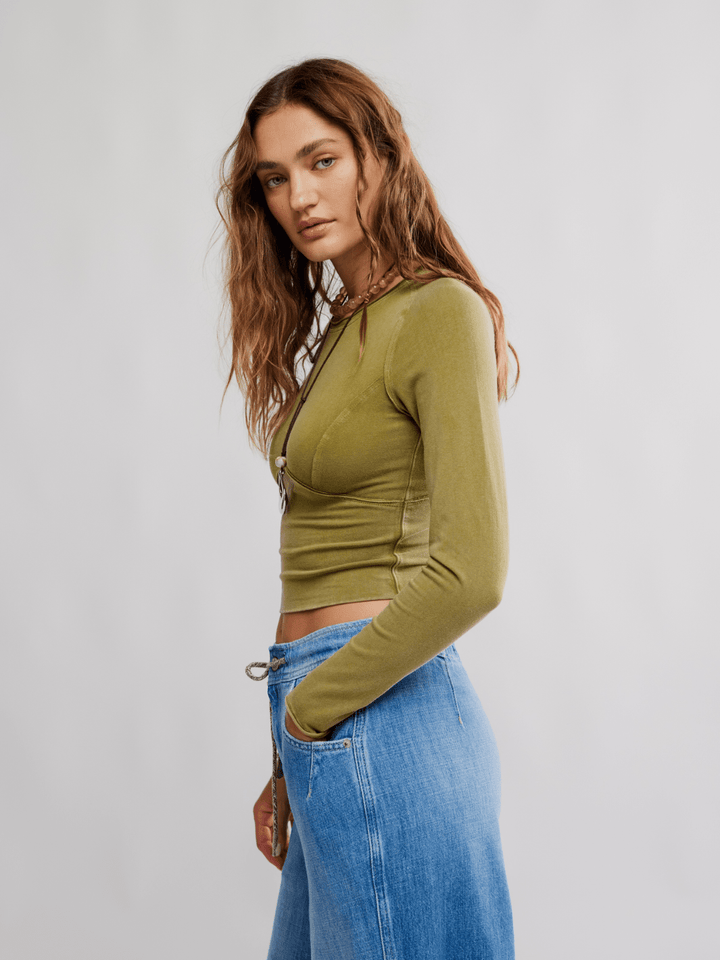 Model wearing olive green The Protagonist Long Sleeve top, cropped fit, paired with blue jeans.