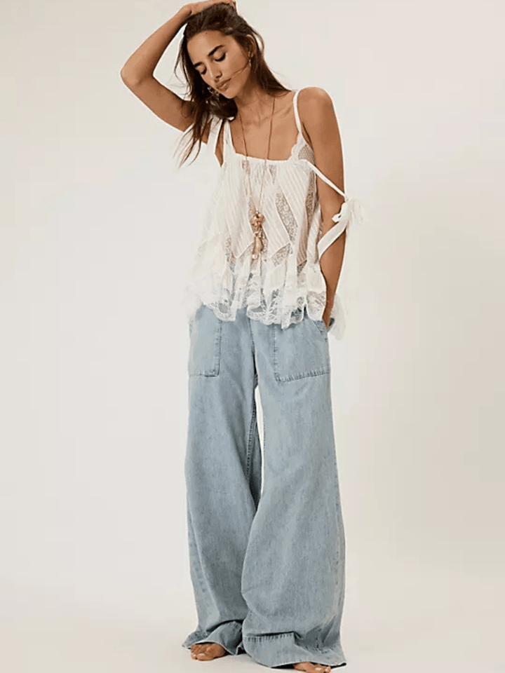 Model in light-wash Free People We The Free Breezy Denim Pull-On Jeans with a wide-leg silhouette.