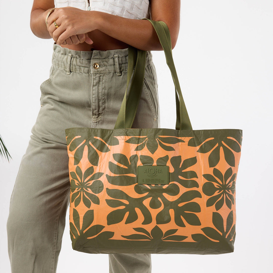 Woman in olive trousers carrying the Kaulu Holo Holo tote on her shoulder