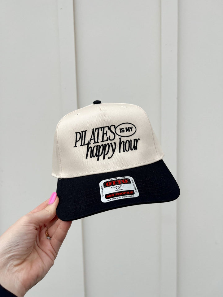 Beige front, black-brim trucker hat with embroidered Pilates Is My Happy Hour slogan.