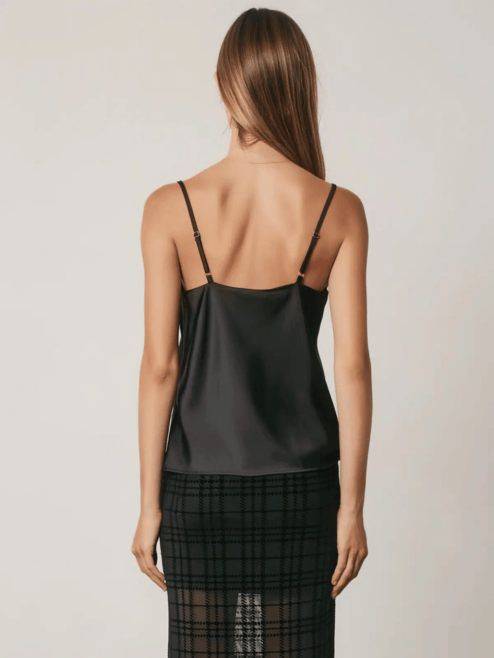 Black satin camisole top with adjustable straps worn on woman back showing square neckline and lustrous finish