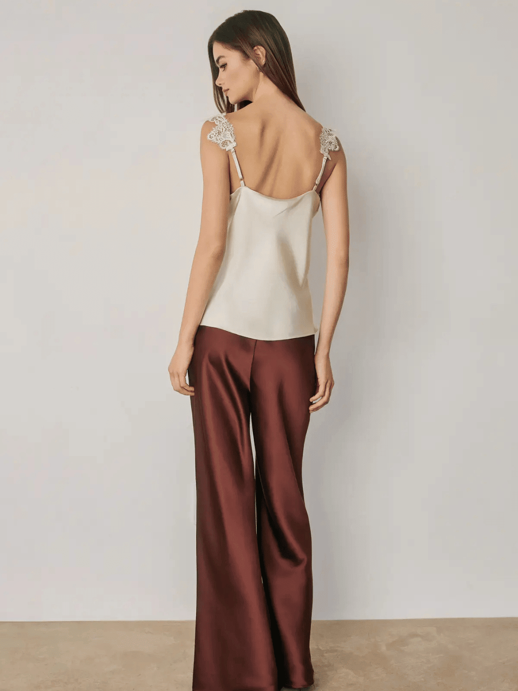 Women wearing red satin straight leg pants with lace detail camisole.