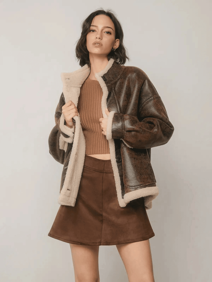 The Renegade Shearling Moto Jacket by Jayden P Boutique, front studio view showing faux leather finish and cream sherpa lining.