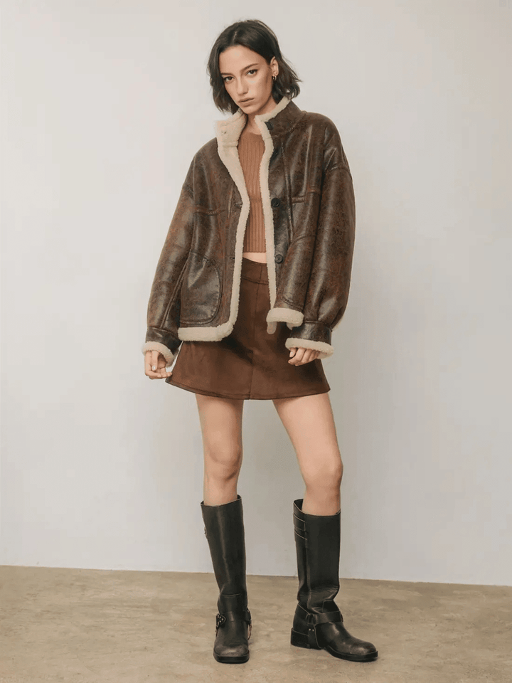 Full-length front view of The Renegade Shearling Moto Jacket in distressed brown, styled with mini skirt and boots by Jayden P Boutique.