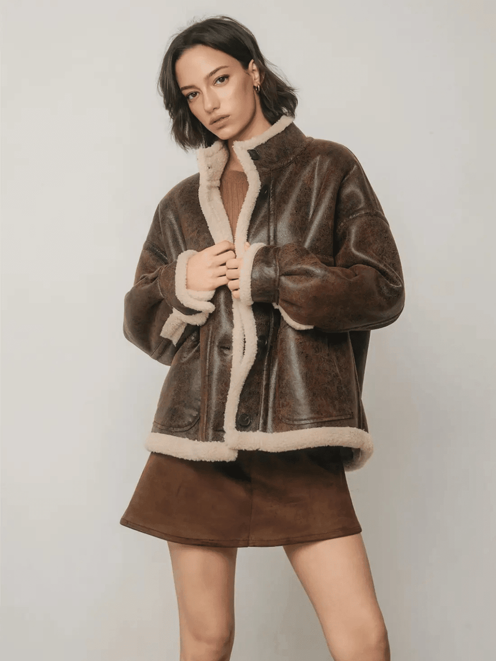The Renegade Shearling Moto Jacket by Jayden P Boutique, front view with high collar, cream sherpa lining and brown mini skirt.