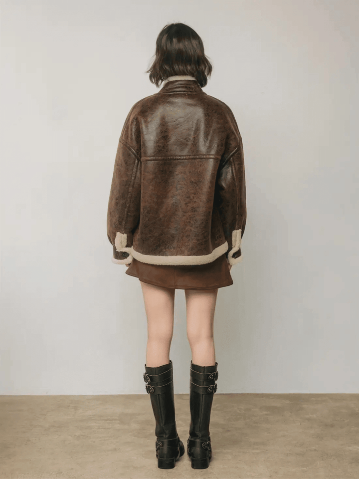 Full-length back view of The Renegade Shearling Moto Jacket in distressed brown, styled with mini skirt and boots by Jayden P Boutique.